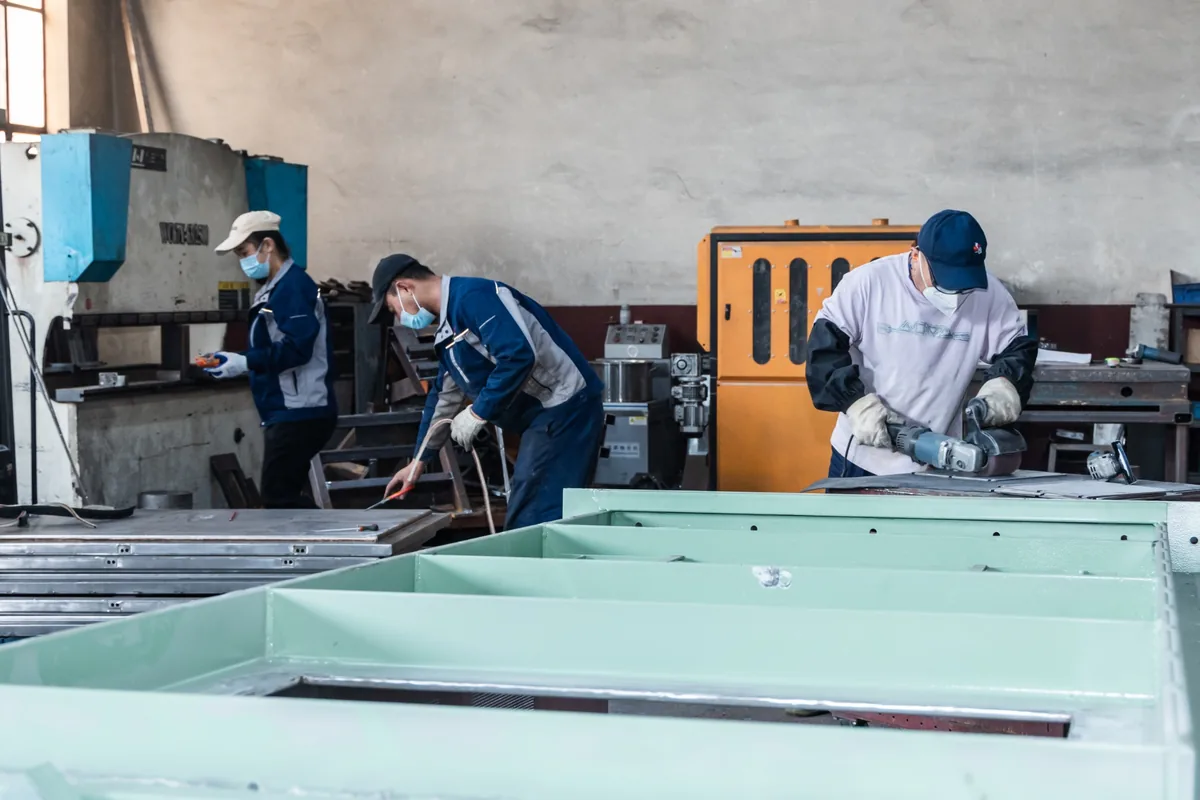 Workers fabricating metal components in the workshop